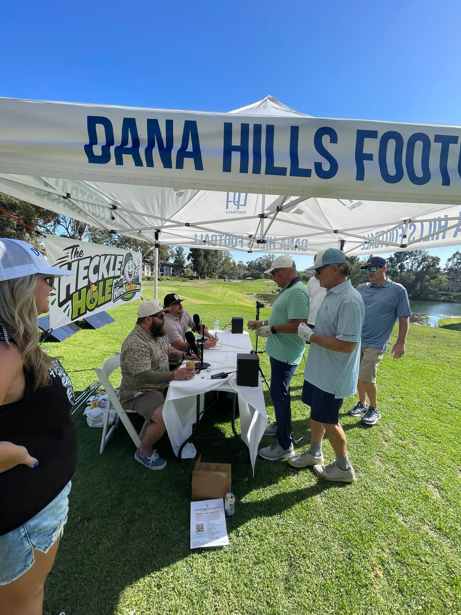 Golfers step up to The Heckle Hole table at the Dana Hills High School football golf tournament