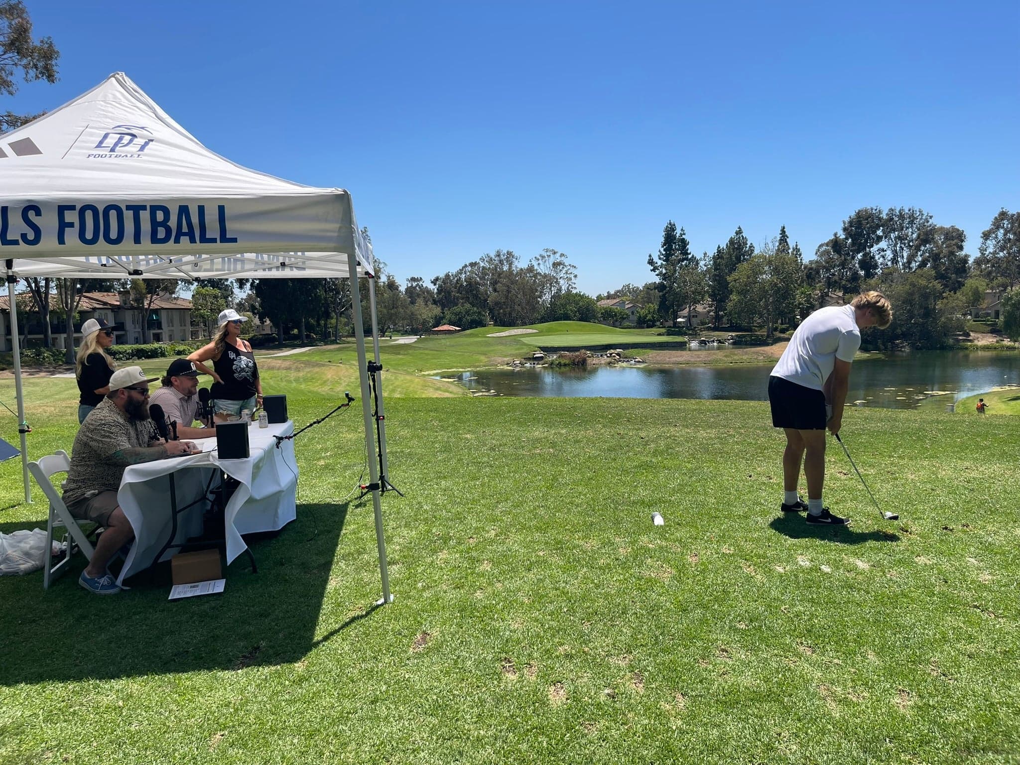 A golfer tees off at The Heckle Hole during the Dana Hills High School Football golf tournament